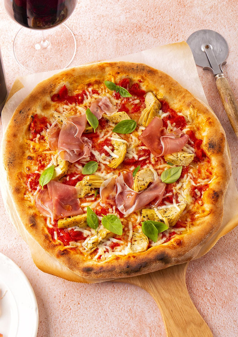 Pizza met tomaat, artisjok, prosciutto en pecorino